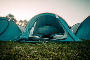 duas tendas verdes sentadas na relva num campo em EuroCup Campsite 2024 em Munique