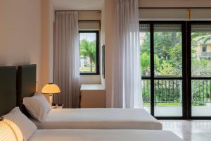 - une chambre avec 2 lits et une grande fenêtre dans l'établissement B&B HOTEL Bari Rondò, à Bari