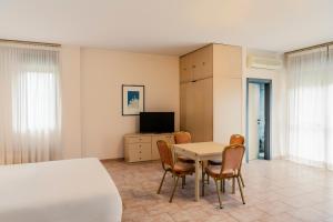 - une chambre avec un lit, une table et des chaises dans l'établissement B&B HOTEL Bari Rondò, à Bari