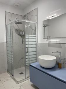 uma casa de banho com uma cabina de duche em vidro e um lavatório. em Le Ghie em Mondovì