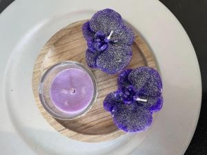 a plate with a purple candle and purple flowers at Le Ghie in Mondovì