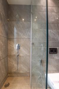 a shower with a glass door in a bathroom at Kohsa7 in Gurgaon