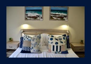 1 dormitorio con 1 cama con almohadas azules y blancas en Rest and Sea Self-catering - The perfect family or couples getaway to relax and refresh, en Franskraalstrand