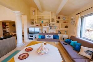 een woonkamer met een bank en een tafel bij La Villa des Cades avec vue mer et piscine privée sur les hauteurs de Stre-Maxime in La Nartelle