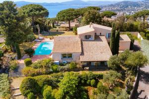 een luchtzicht op een huis met een zwembad bij La Villa des Cades avec vue mer et piscine privée sur les hauteurs de Stre-Maxime in La Nartelle