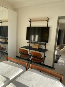 - une chambre avec un lit et un bureau avec des chaises dans l'établissement Appart 60 m2 séjour sur terrasse sud et 2 chambres gare Saint-Charles, à Marseille