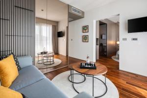 a living room with a blue couch and two tables at Boutique Hotel Adoral in Rabac