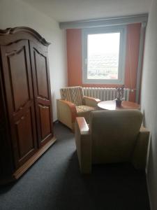 Zimmer mit Sofa, Tisch und Fenster in der Unterkunft TWS Pension an der B1 in Magdeburg
