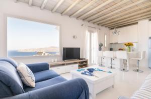 a living room with a blue couch and a table at Margarita House in Mýkonos City