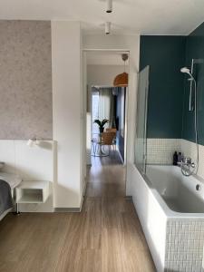 ein Badezimmer mit einer weißen Badewanne und einer grünen Wand in der Unterkunft TreeTop Studio near MTP in Posen