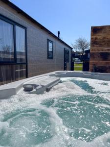 a hot tub with water in front of a house at Applegrove Country Park, Scarborough with Private Hot Tubs in Burniston