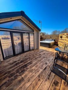 a large deck with a table and a grill at Applegrove Country Park, Scarborough with Private Hot Tubs in Burniston