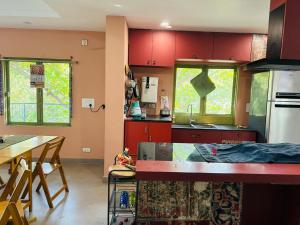 eine Küche mit roten Schränken, einem Tisch und einer Theke in der Unterkunft ARTHAUZ Events in Visakhapatnam