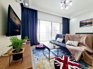 a living room with a blue couch and a large window at 11 Guest Comfy 3 Room Koi Kinrara Suite, IOI Puchong, Bukit Jalil Pavilion, Bukit Jalil Stadium, Sunway Pyramid, Sunway Lagoon in Kampong Baharu Sungai Way