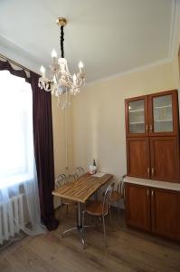 a dining room table with chairs and a chandelier at Apartments on Sobornaya Street near the waterfront in Mykolaiv
