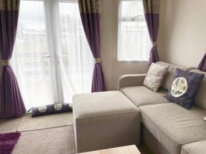 a living room with purple curtains and a couch at 'Oakley' Boat of Garten Holiday Park in Boat of Garten