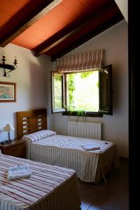 two beds in a room with a window at Casas Rurales Cortijo El Marqués in Quesada