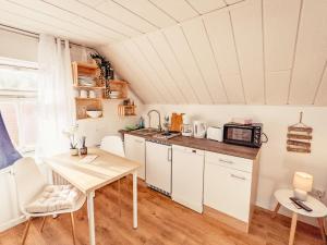 eine kleine Küche mit einem Tisch und einer Mikrowelle in der Unterkunft Urlaubsmagie - Wohlfühloase mit Pool - H5 in Sebnitz