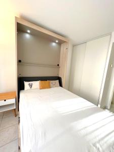 1 dormitorio con 1 cama blanca grande. en Palazzio 3, quartier vieux port avec parking, by Welcome to Cannes en Cannes