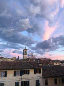 um edifício com uma torre de relógio sob um céu nublado em Sotto le stelle delle balze em Castelfranco di Sopra
