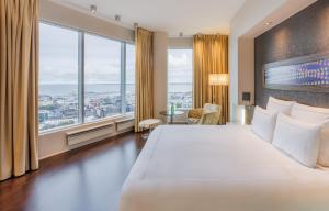 a hotel room with a large bed and large windows at Swissotel Tallinn in Tallinn