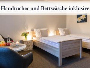1 dormitorio con 2 camas y mesa con silla en Blumenvilla 1 mit begehbarer Dusche, Sauna und Garten, en Schneverdingen