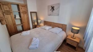 a bedroom with a large bed with two towels on it at FRGK "Charme alpin et confort moderne" in Saint-Étienne-de-Tinée