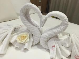 Dos cisnes hechos de toallas en una cama en Residence Eleonora en Sottomarina