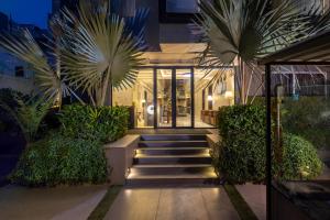 a house with stairs and palm trees in front of it at Kohsa7 in Gurgaon