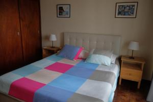 フンシャルにあるLenamarのベッドルーム1室(大型ベッド1台、カラフルな毛布付)