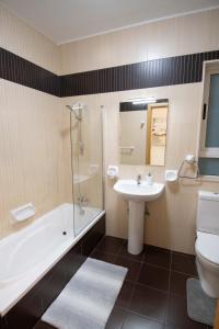 uma casa de banho com um lavatório, uma banheira e um WC. em Venus Apartment em Sliema