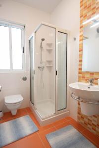 uma casa de banho com um chuveiro, um WC e um lavatório. em Venus Apartment em Sliema