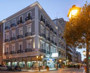 un gran edificio blanco en una calle de la ciudad en SoClà Boutique Hotel, en Taranto