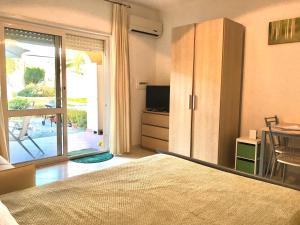 1 dormitorio con 1 cama, TV y mesa en Pizzo Beach Studios Apartments, en Pizzo