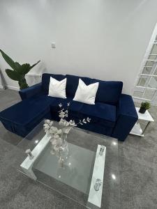 a blue couch in a living room with a table at Charming 3-Bed House in Staines in Staines