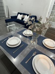 a table with plates and forks and glasses on it at Charming 3-Bed House in Staines in Staines