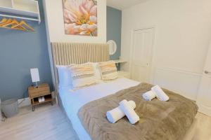 a bedroom with a large bed with towels on it at New King-size bed en-suit, luxury refurbished home in Newark upon Trent