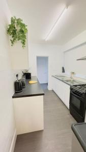 a kitchen with white counters and a black stove at New King-size bed en-suit, luxury refurbished home in Newark upon Trent