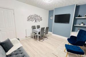 a living room with a couch and a table with chairs at New King-size bed en-suit, luxury refurbished home in Newark upon Trent