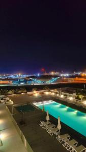 a swimming pool at night with chairs and lights at Silk Valley - Furnished 2bhk Close To Metro in Dubai Marina