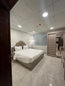 een slaapkamer met een groot bed en een spiegel bij الساعه 60 الفندقيه in Dammam