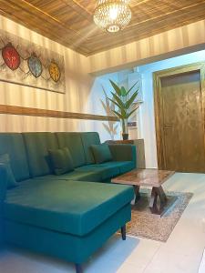 uma sala de estar com um sofá azul e uma mesa em RUDISH COTTAGE (COZY & PRIVATE) em Abuja