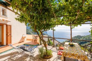 eine Terrasse mit einem Tisch und Stühlen sowie Meerblick in der Unterkunft La CaPAnnetta in Ravello
