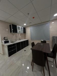 uma cozinha com mesa e cadeiras num quarto em الساعه 60 الفندقيه em Dammam