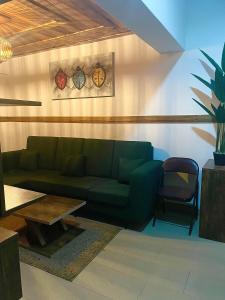 a living room with a green couch and a table at RUDISH COTTAGE (COZY & PRIVATE) in Abuja