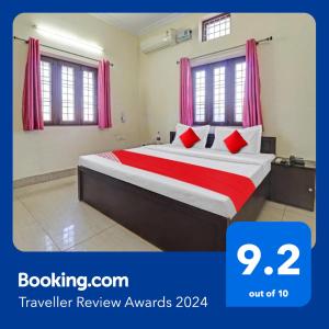 una camera da letto con un grande letto con cuscini rossi di Balindira Guest House a Dehradun