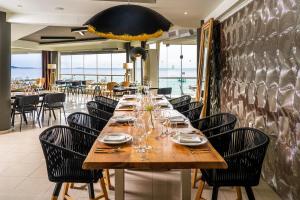 a long wooden table in a restaurant with chairs at Trypiti Resort Blue Dream Palace and Hive Water Park in Limenaria +37 photos