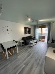 a living room with a couch and a clock on the wall at Rock&Bike Calpe Sunny Apartment in Calpe