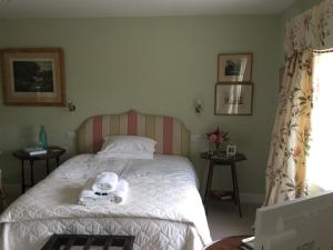 a bedroom with a bed with towels on it at Clare Cottage in Sherborne