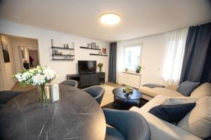 un soggiorno con un tavolo e un divano di Bloßfeld-Apartments Geräumige Stadtoase mitten im Zentrum mit 3 Schlafzimmern, Gratis Parkplatz, W-Lan, Netflix a Jena